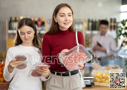 Woman and her teenage daughter choosing hamburger or beef entrecote in grocery