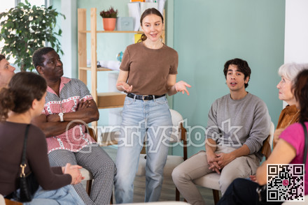 European woman talking to a group of people in the office