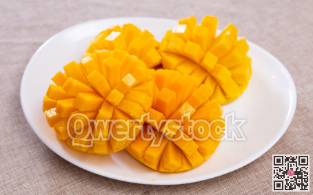 Deliciously served fresh mangoes diced and laid out on plate