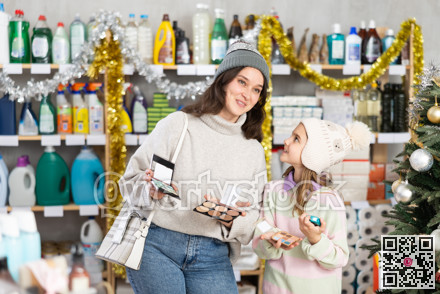 Mother and daughter shopping for cosmetics together during Christmas at home goods store