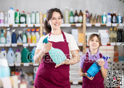 Portrait of two positive adult and little salespeople in household goods supermarket