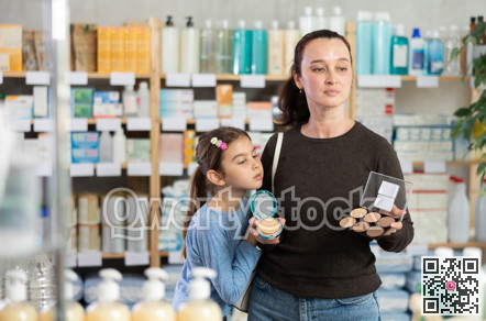 woman and daughter choose cosmetics in a pharmacy near the shelves