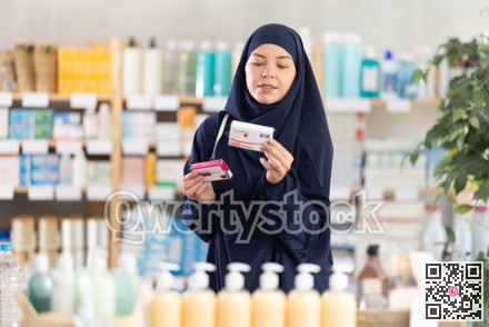 Young Muslim woman customer choosing paracetamol in drugstore