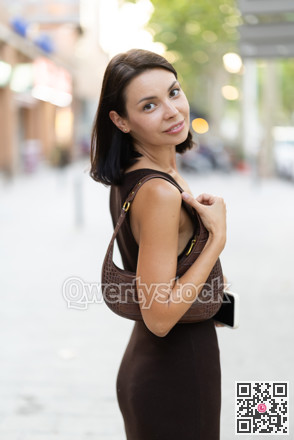 Slender female brunette walks in vicinity of Passeig Nou in Barceloneta