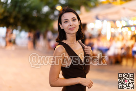 In evening, smiling girl walks around old city district Barceloneta, in vicinage of Citadel Park
