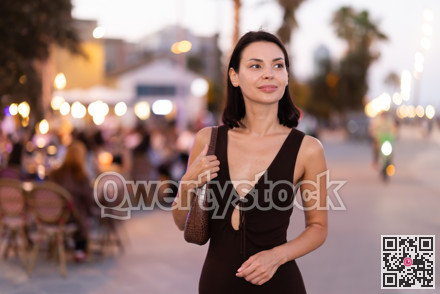 In evening, girl walks around old city district Barceloneta, pedestrian embankment