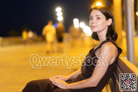Young woman sitting on bench on seaside promenade of Barcelona