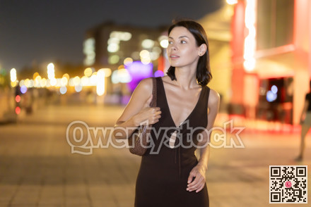 At night, smiling girl walks around old city district Barceloneta, in vicinage of Passeig Nou