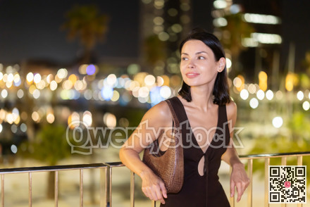 At night, smiling girl walks around old city district Barceloneta, in vicinage of Citadel Park