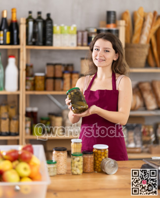 Young woman seller with pickled cucumbers
