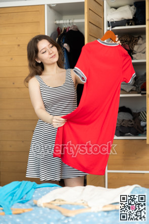 Young woman choosing which dress to wear
