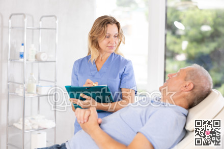 Middle-aged female doctor signing papers while talking with man patient