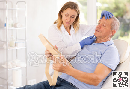 Female cosmetologist consulting senior man before facial treatments