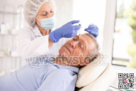 Woman cosmetologist makes injection in forehead of man