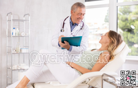 Male doctor carries out questionnaire survey of woman after procedure