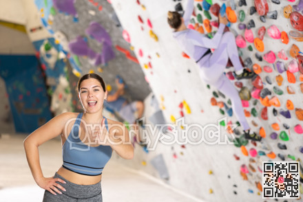 Young woman posing on climbing wall