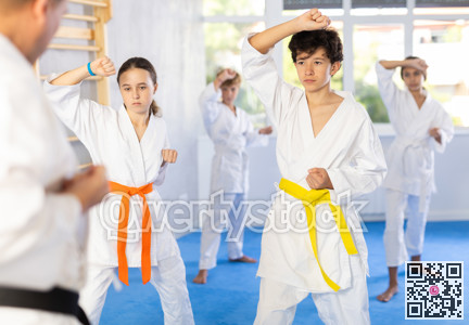 Group of children train karate techniques