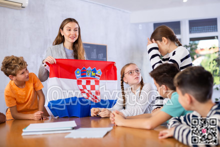 Teacher showing Croatia flag to group of schoolchildren