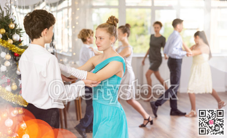 Boy and girl dancing waltz in studio