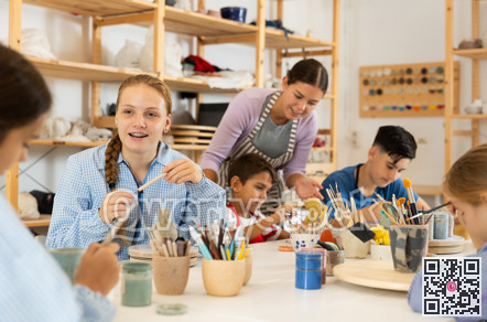 Teenage girl speaking to a circle member while processing ceramic items