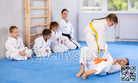 Children athletes in pair conduct training battle in oriental fighting technique