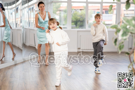 Tween girl and boy rehearsing popping techniques in street dance studio