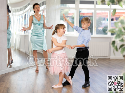 Boy and girl in pair train to dance contemporary vigorous waltz during classes.