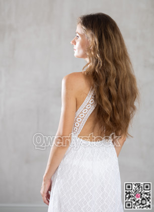 Young serious woman posing against wall background