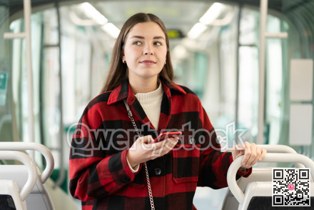 Girl with long hair standing in tram with phone