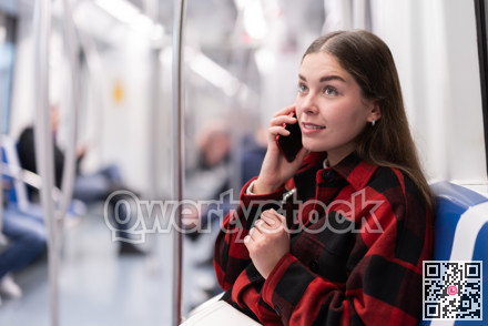 girl sitting in subway car with phone