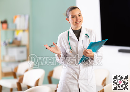 Portrait of young coach female doctor standing with folder with documents and materials in hands and talking in corporate seminar and inviting in auditorium