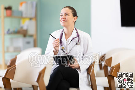 Female medical student listening to lecture in classroom with tablet