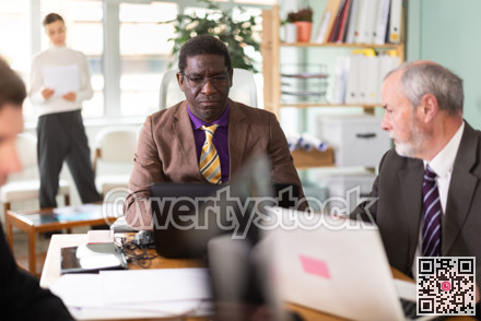 African man working in office with team