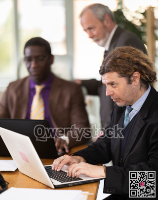 Man sitting at desk is working on laptop computer. Working day in office