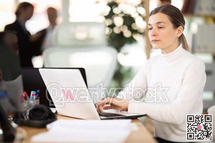 Businesswoman works in company office along with other office workers