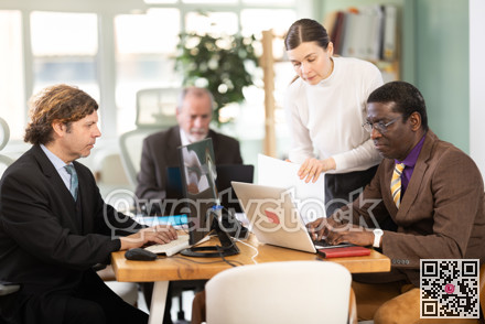 Businessmen use laptops during a conference in meeting room with colleagues