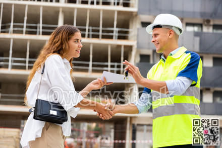 Smiling man contractor gives a young female customer the keys