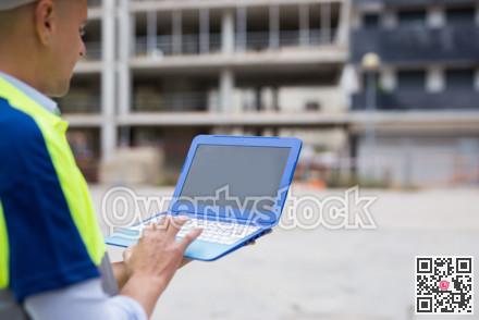 Engineer with laptop in construction site
