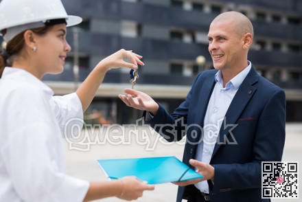 Builder giving keys to client after finishing signing contract