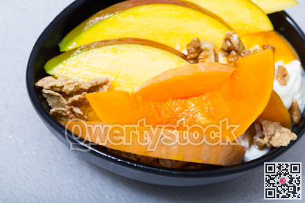 Tasty pumpkin and mango served with whipped cream and oat-flakes at plate
