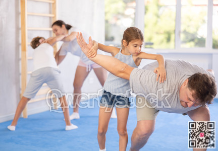 Father teaches his little daughter to use forceful techniques and grips during self defense classes