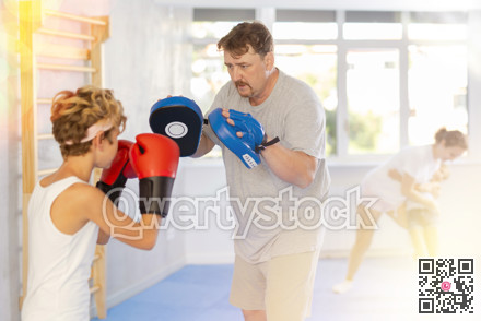 Father and son training boxing in studio