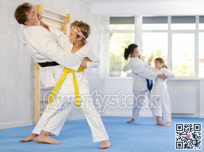 Parent with child athletes in pair conduct training battle in oriental fighting technique