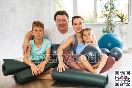 Family with two children posing with pilates equipment