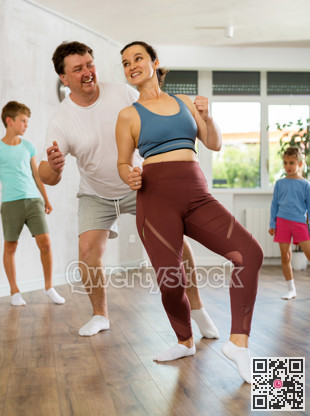 Parents with young daughter and schoolboy son are taught to move to boogie-woogie