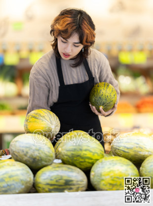 Young woman seller puts melon in store
