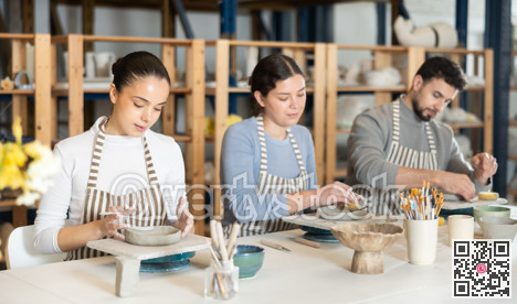 Three pottery workshop workers sculpt from clay, form final product