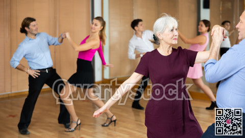 Elderly woman dancing playful balboa with partner in studio