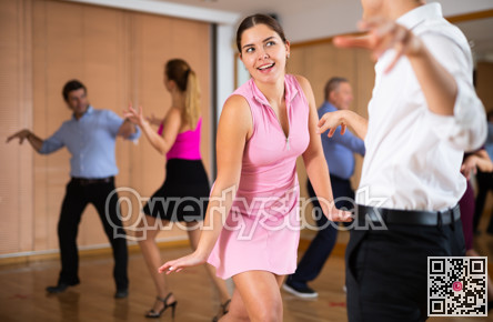 Cheerful female dancer practicing ballroom dances in ballroom