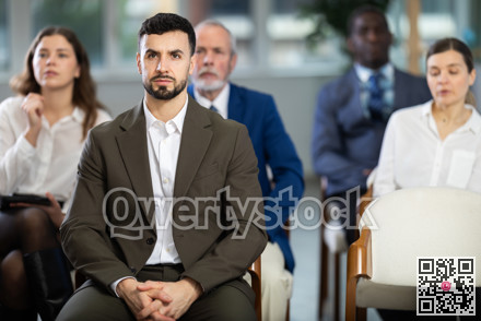 Young man listens to presentation in conference room
